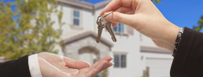 Handing Over The New House Keys with Home in the Background.